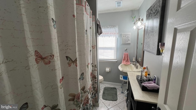 bathroom with visible vents, toilet, vanity, baseboards, and tile patterned floors