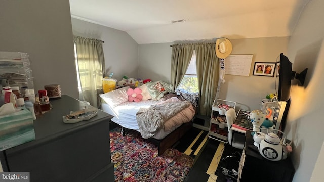 bedroom with lofted ceiling and visible vents