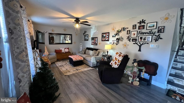 living room with ceiling fan, baseboards, and wood finished floors