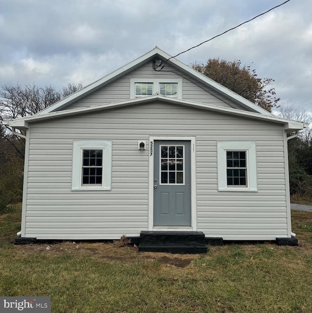 rear view of house featuring a yard