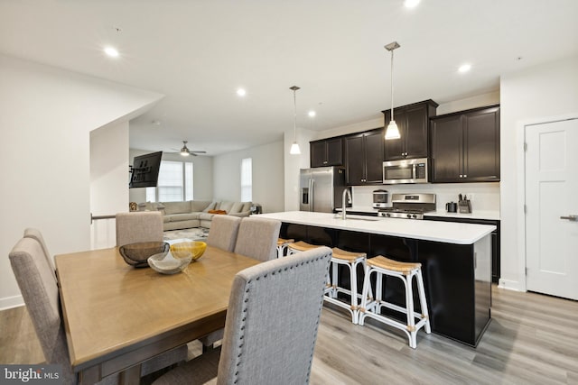 dining space featuring ceiling fan, sink, and light hardwood / wood-style floors