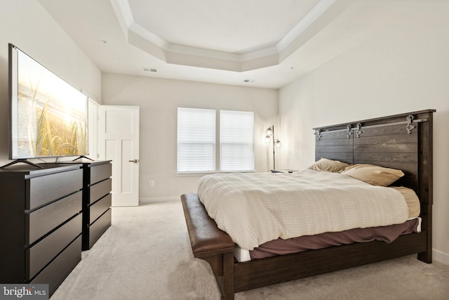 bedroom featuring a tray ceiling and light carpet