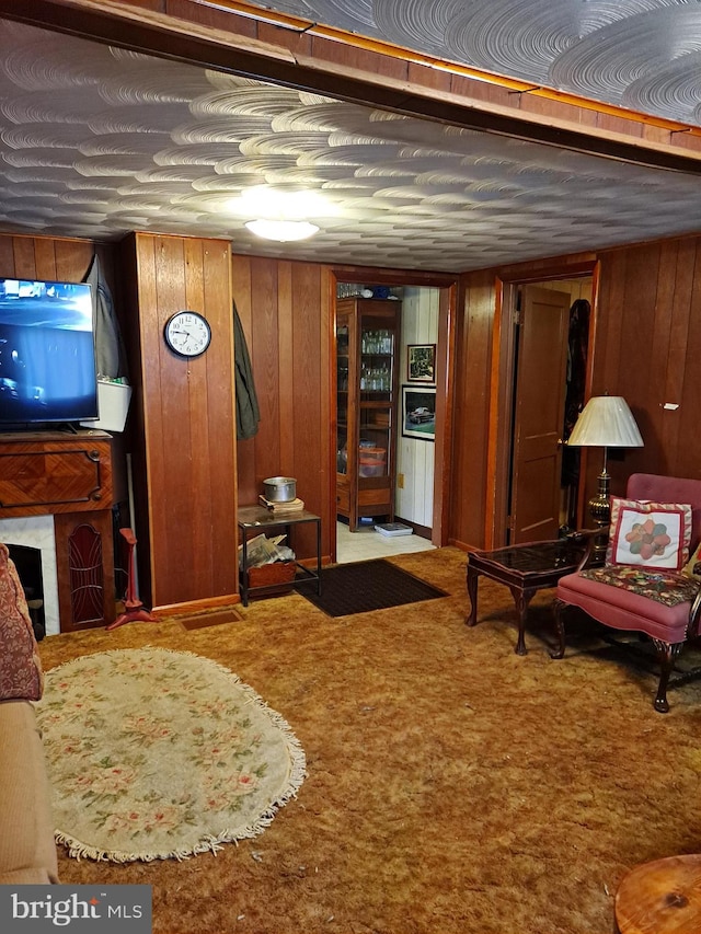 sitting room featuring light carpet and wooden walls