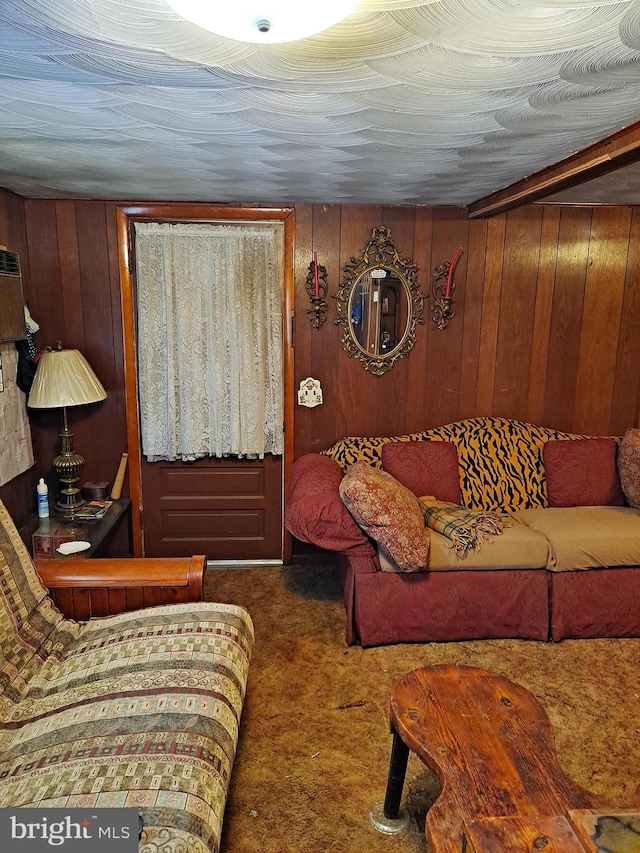 carpeted living room with wood walls