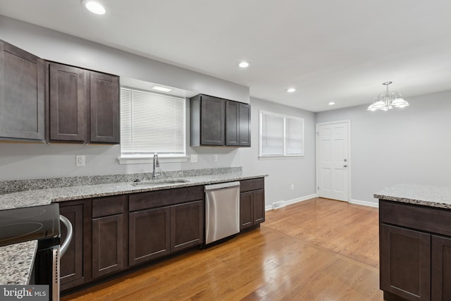 kitchen with stainless steel appliances, sink, decorative light fixtures, light hardwood / wood-style flooring, and a notable chandelier