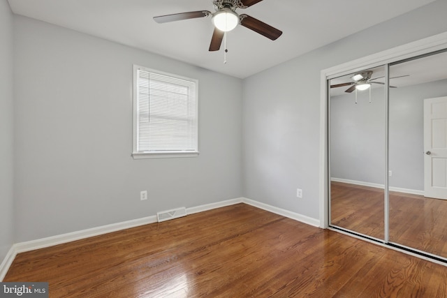 unfurnished bedroom with ceiling fan, a closet, and wood-type flooring