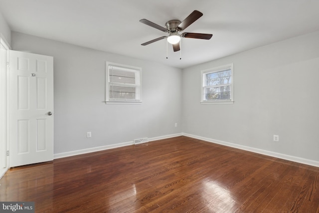 spare room with dark hardwood / wood-style floors and ceiling fan