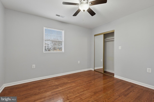 unfurnished bedroom featuring a closet, ceiling fan, and dark hardwood / wood-style flooring