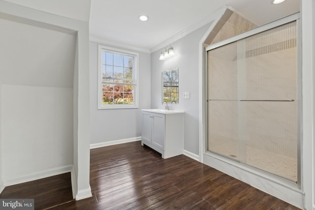 bathroom featuring vanity, wood-type flooring, ornamental molding, and walk in shower