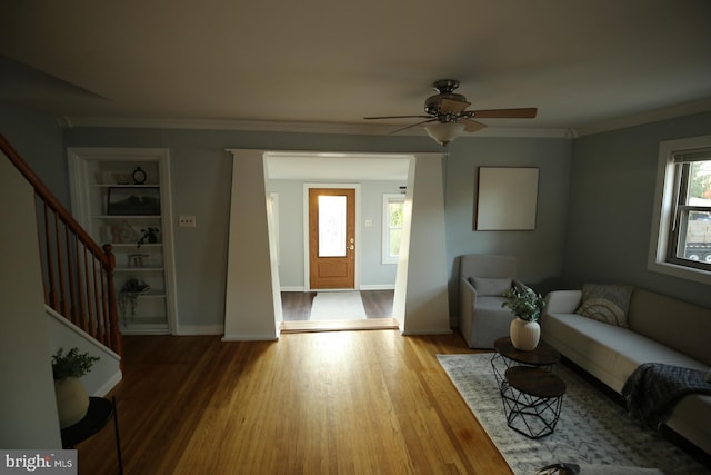 living room featuring ceiling fan, crown molding, and light hardwood / wood-style flooring