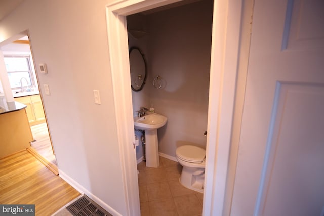 bathroom featuring hardwood / wood-style floors and toilet