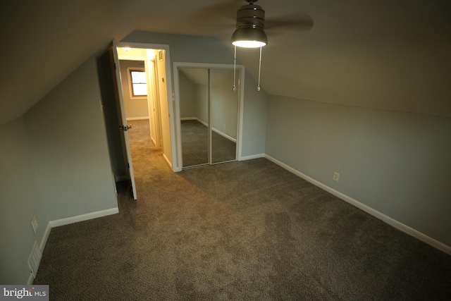 additional living space with ceiling fan, vaulted ceiling, and dark colored carpet