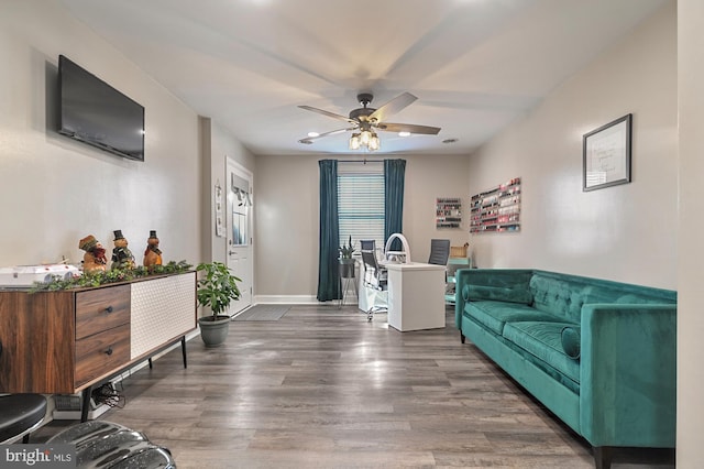 living room featuring ceiling fan and dark wood-type flooring