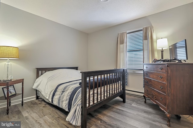 bedroom featuring a textured ceiling and hardwood / wood-style flooring