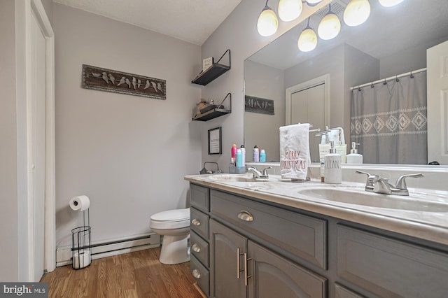 bathroom with a baseboard heating unit, a textured ceiling, toilet, vanity, and hardwood / wood-style flooring