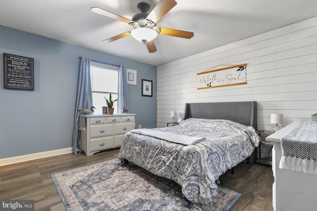 bedroom featuring a textured ceiling, dark hardwood / wood-style floors, and ceiling fan