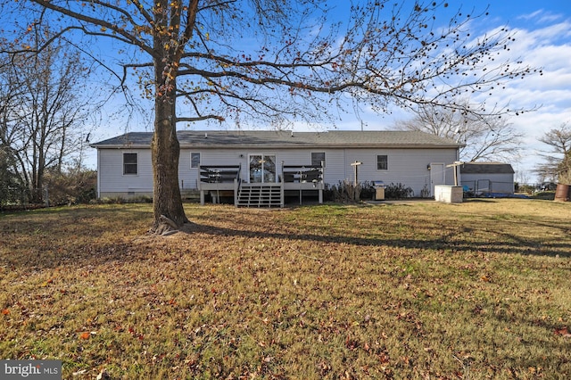 rear view of house featuring a lawn and a deck