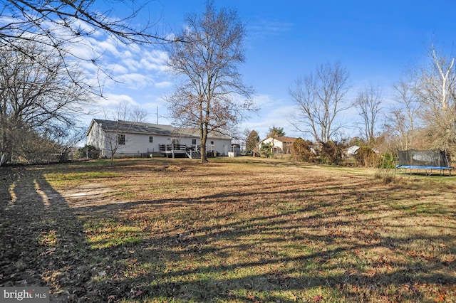 view of yard featuring a deck and a trampoline