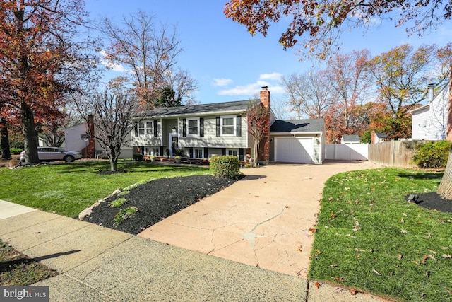 bi-level home with a garage and a front lawn