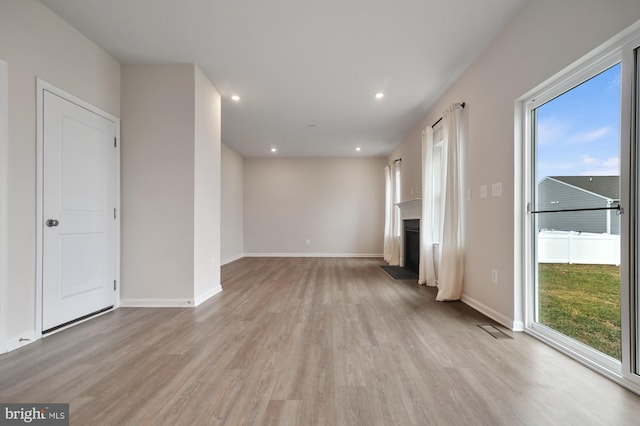 unfurnished living room with light hardwood / wood-style floors and a wealth of natural light