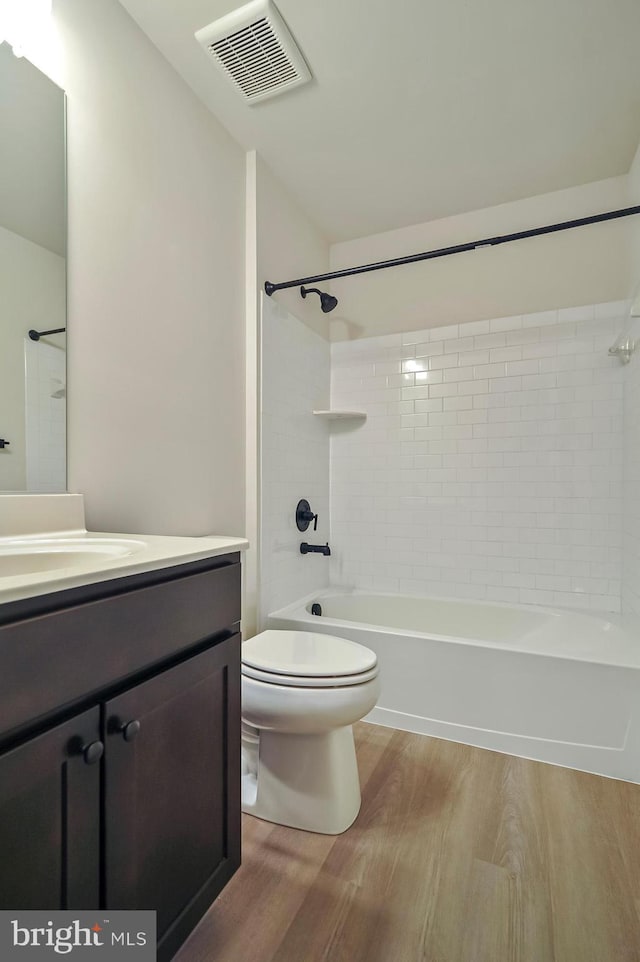 full bathroom with wood-type flooring, vanity, toilet, and tiled shower / bath combo