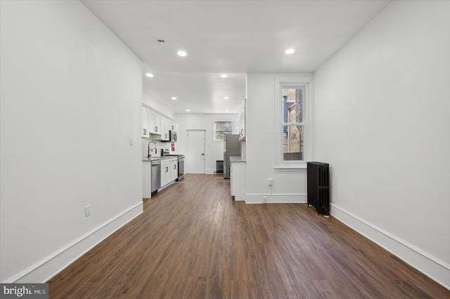 unfurnished living room with radiator and dark hardwood / wood-style flooring