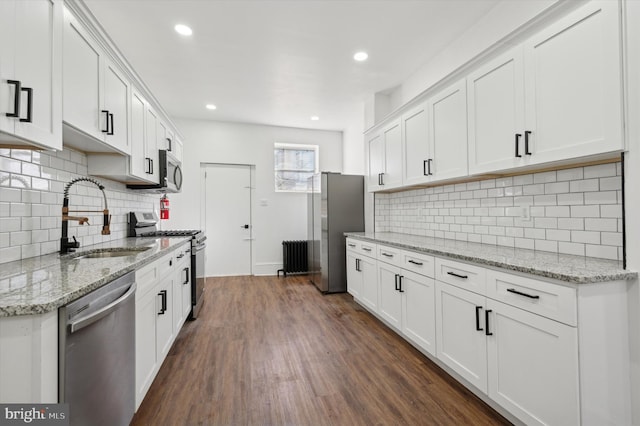 kitchen featuring white cabinets, sink, stainless steel appliances, and dark wood-type flooring