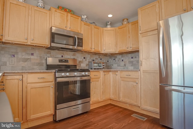 kitchen with dark hardwood / wood-style floors, light brown cabinets, light stone counters, and stainless steel appliances