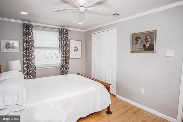 bedroom featuring hardwood / wood-style floors, ceiling fan, ornamental molding, and a closet