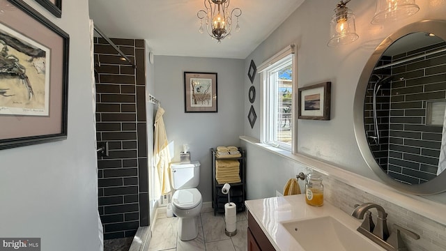 bathroom featuring a shower with shower curtain, vanity, an inviting chandelier, and toilet