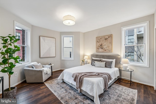 bedroom with multiple windows and dark hardwood / wood-style flooring