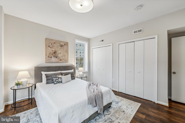 bedroom featuring multiple closets and dark hardwood / wood-style flooring