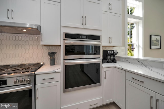 kitchen featuring backsplash, white cabinetry, and stainless steel appliances