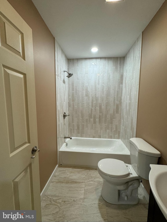 full bathroom with tiled shower / bath combo, sink, and toilet