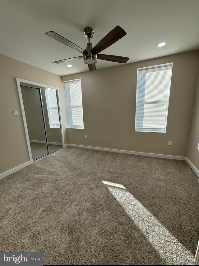 unfurnished bedroom with carpet floors, ceiling fan, and a closet