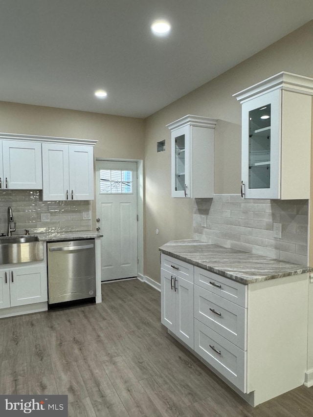 kitchen with white cabinetry, stainless steel dishwasher, sink, and light hardwood / wood-style flooring