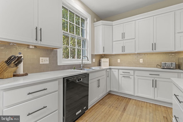 kitchen with sink, dishwasher, light hardwood / wood-style flooring, backsplash, and white cabinets