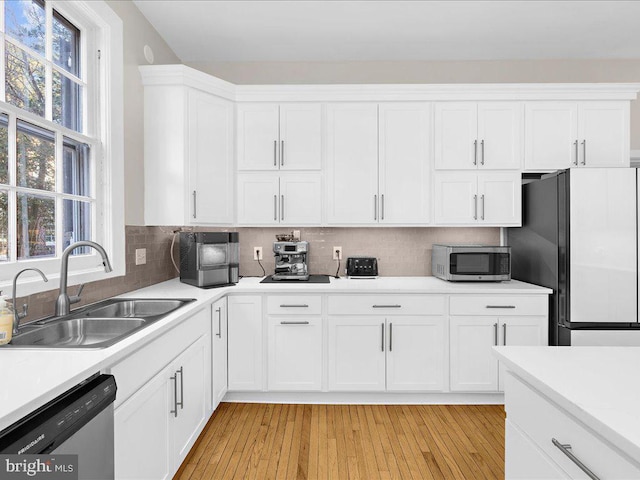 kitchen with white cabinetry, sink, light hardwood / wood-style flooring, and appliances with stainless steel finishes