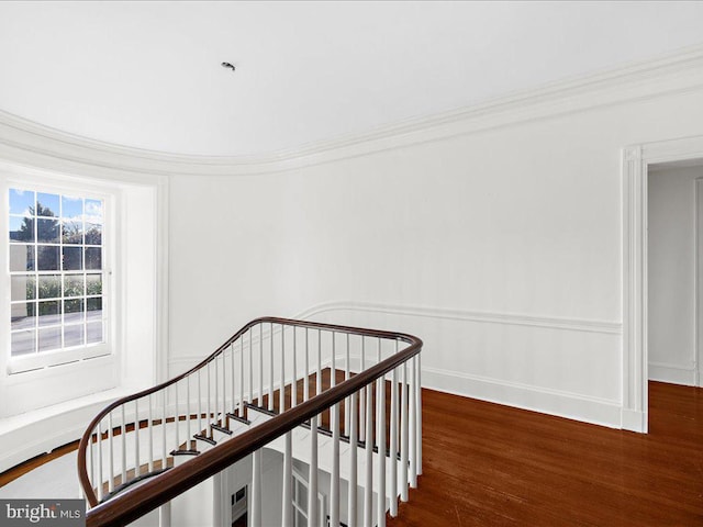 stairway featuring crown molding and wood-type flooring