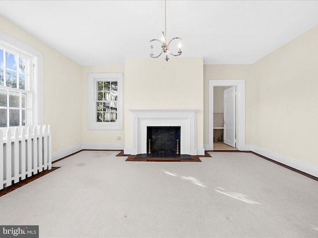 unfurnished living room featuring carpet, a chandelier, radiator, and a healthy amount of sunlight