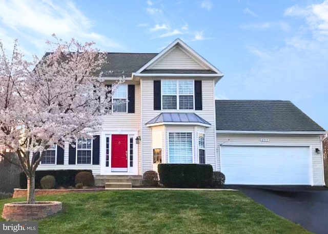 view of front of property featuring a front lawn and a garage