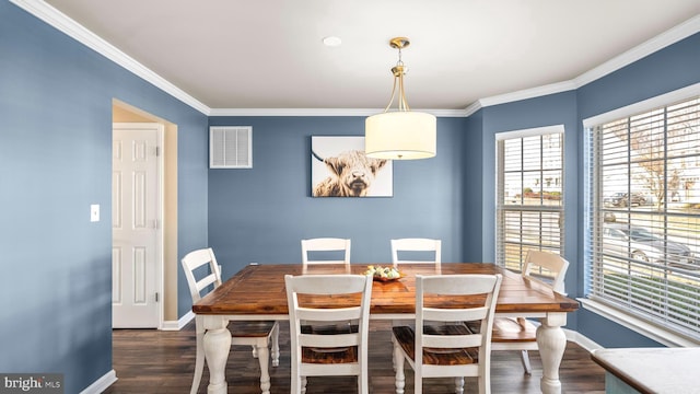 dining space with ornamental molding and dark wood-type flooring