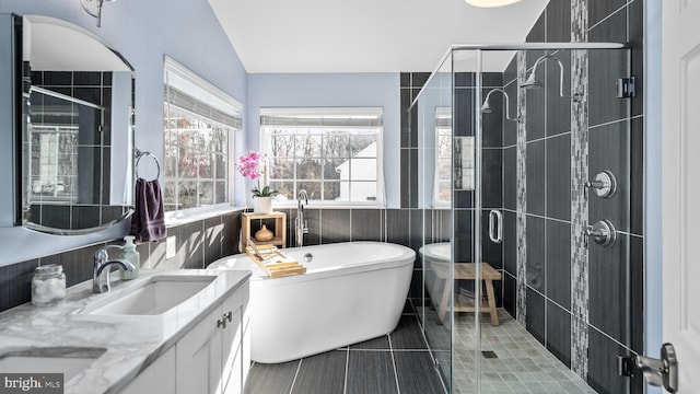 bathroom with tile patterned flooring, vanity, lofted ceiling, and independent shower and bath