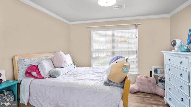 bedroom featuring ornamental molding and light hardwood / wood-style flooring