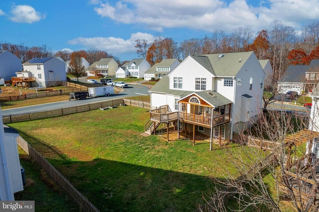 back of property with a lawn and a wooden deck