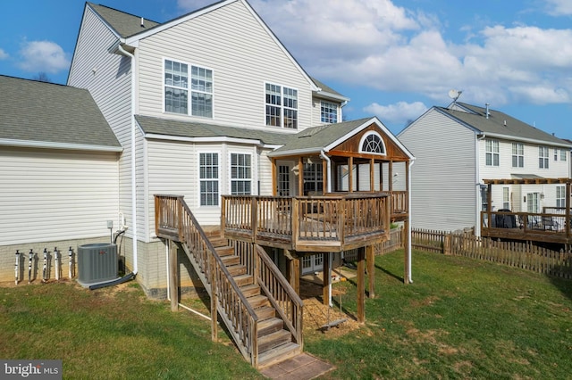 rear view of property with central AC unit, a lawn, and a wooden deck