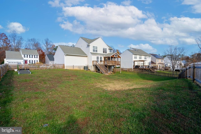 rear view of house with cooling unit, a deck, and a yard