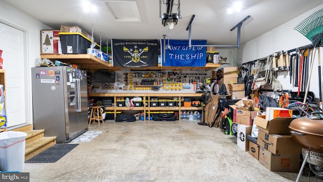 garage with a workshop area and stainless steel fridge with ice dispenser