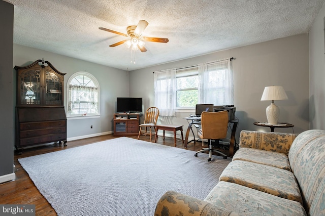 living room featuring a textured ceiling, ceiling fan, and dark hardwood / wood-style floors