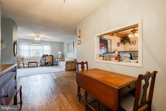 dining space featuring hardwood / wood-style floors, a textured ceiling, and ceiling fan